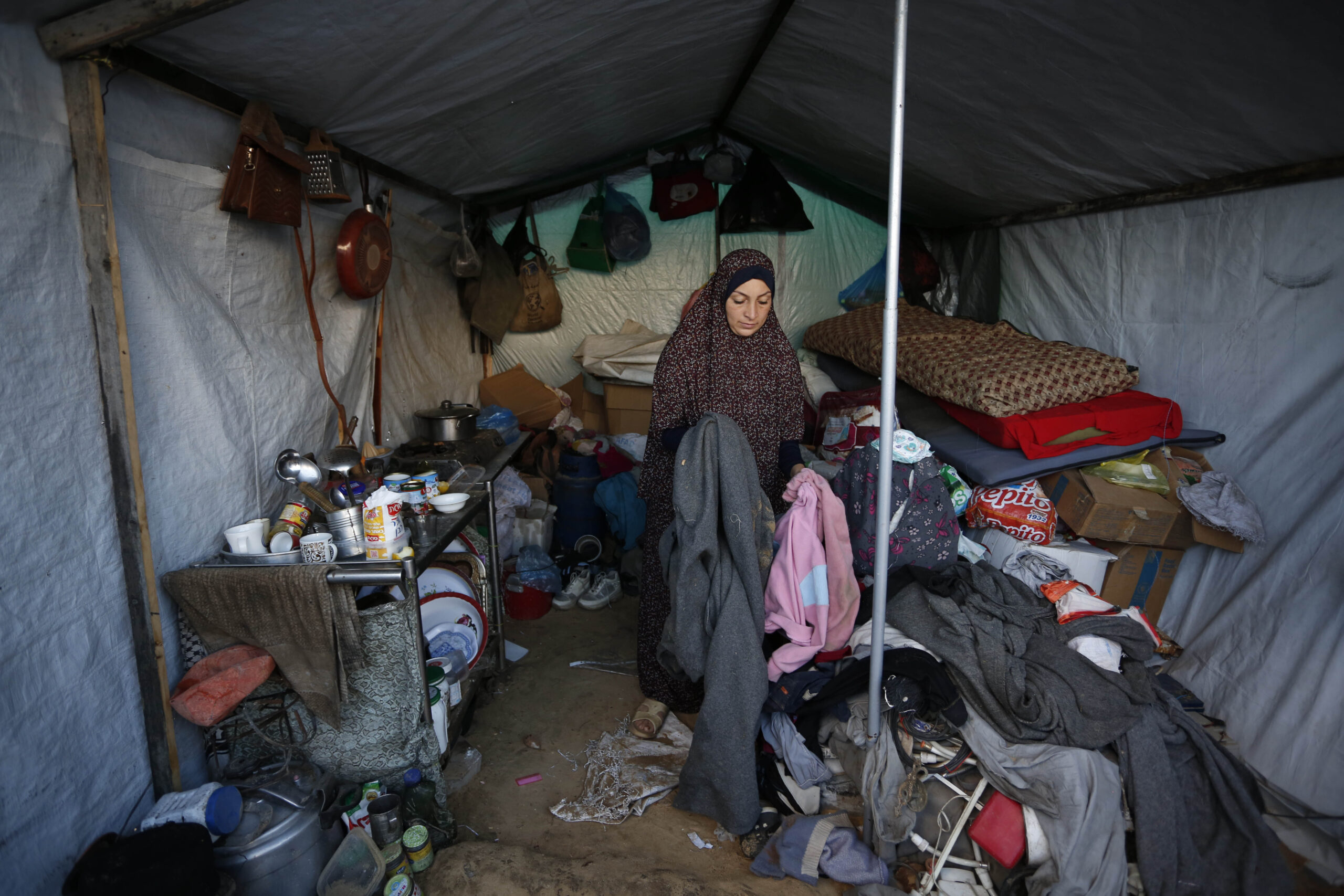 Mujer desplazada en tienda inundada en Gaza