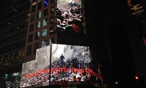 Icónica imagen de UNRWA durante una distribución humanitaria en el campamento de Yarmouk, Damasco, 2014, mostrada en una pantalla de Times Square en Nueva York, 20 de marzo de 2014.