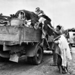 Personas palestinas intentan subir en un camión para huir en la Nakba de 1948