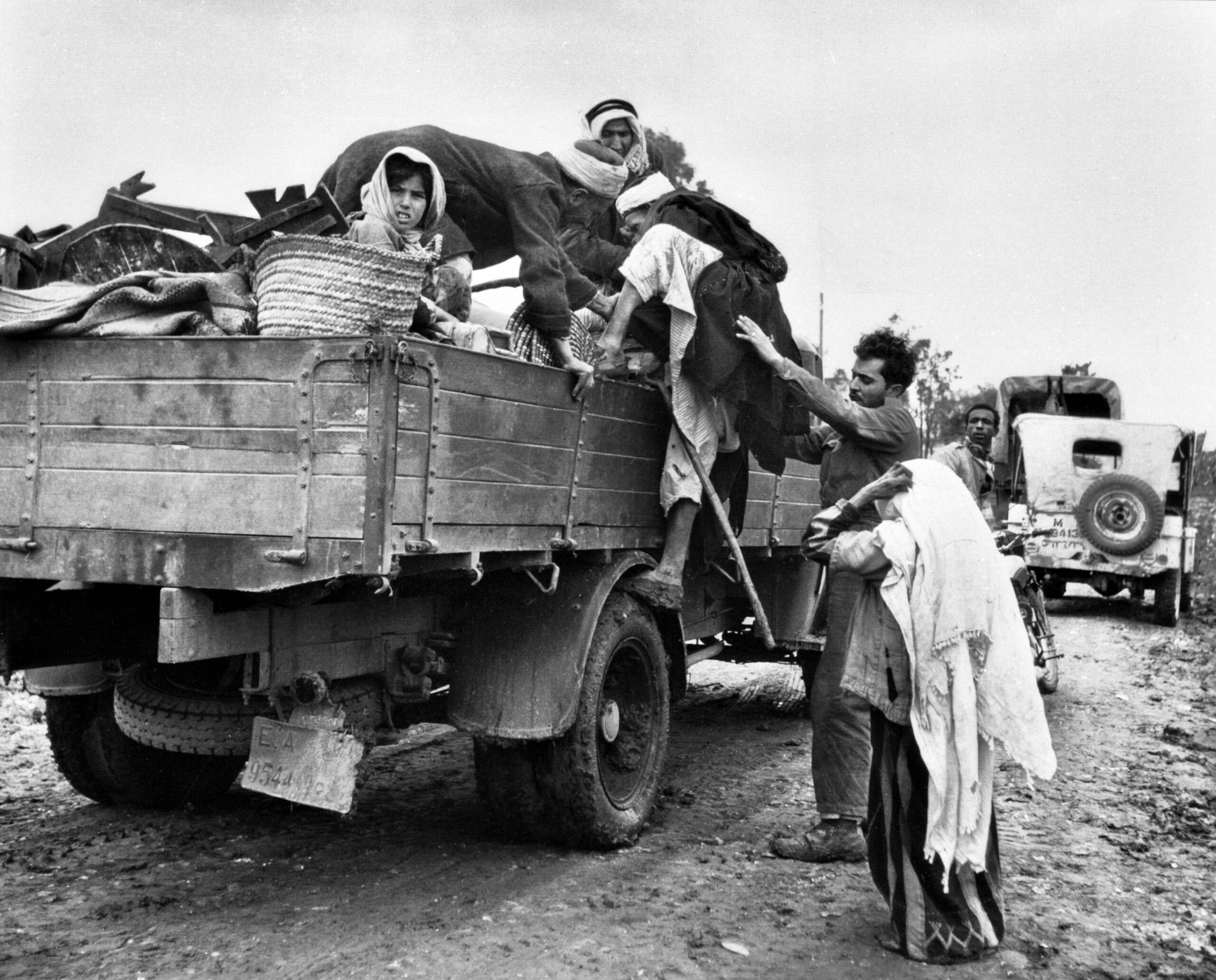 Personas palestinas intentan subir en un camión para huir en la Nakba de 1948