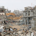 Destrucción de infraestructuras en Gaza con edificios derribados y personas entre los escombros.
